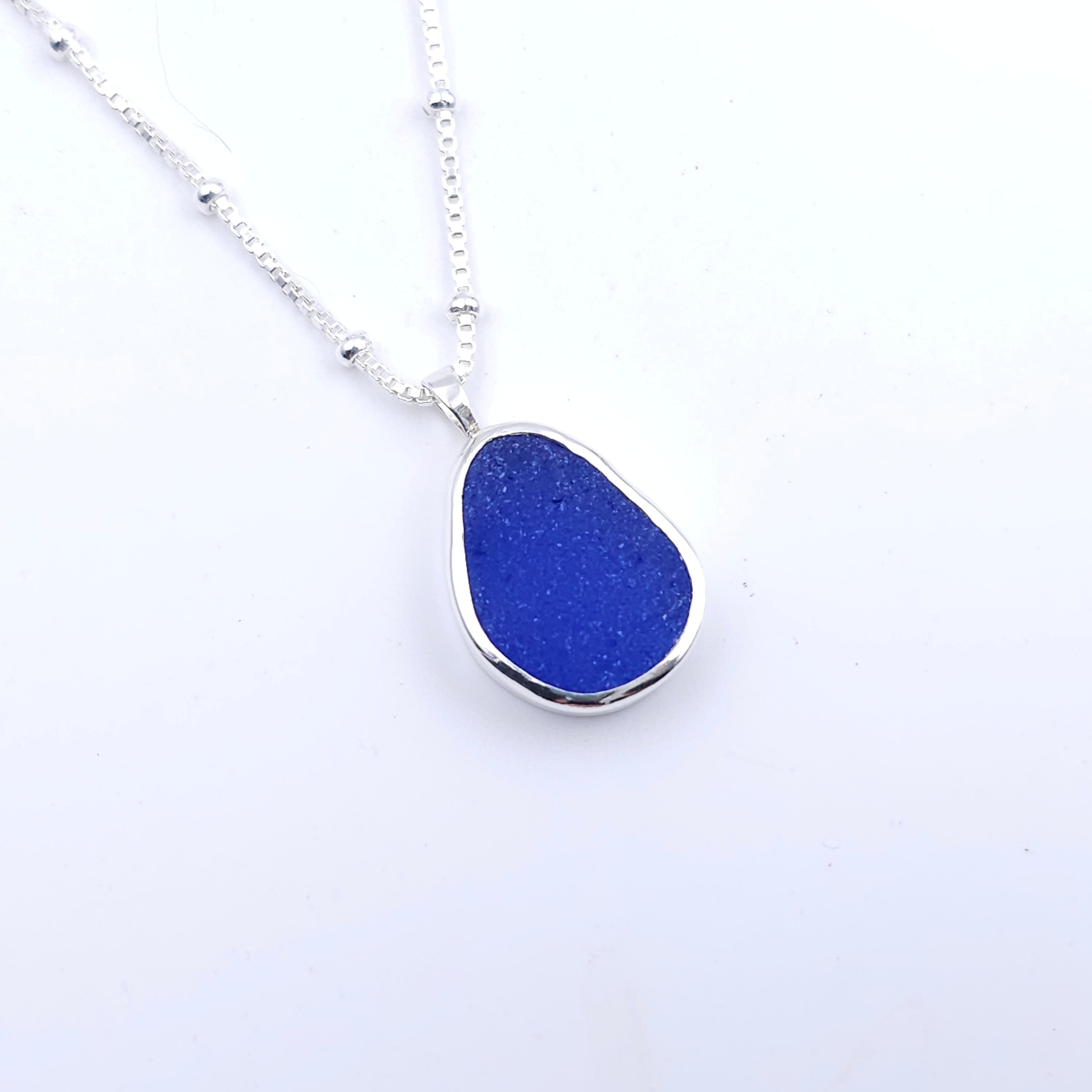 Blue teardrop shaped bezel set silver sea glass necklace