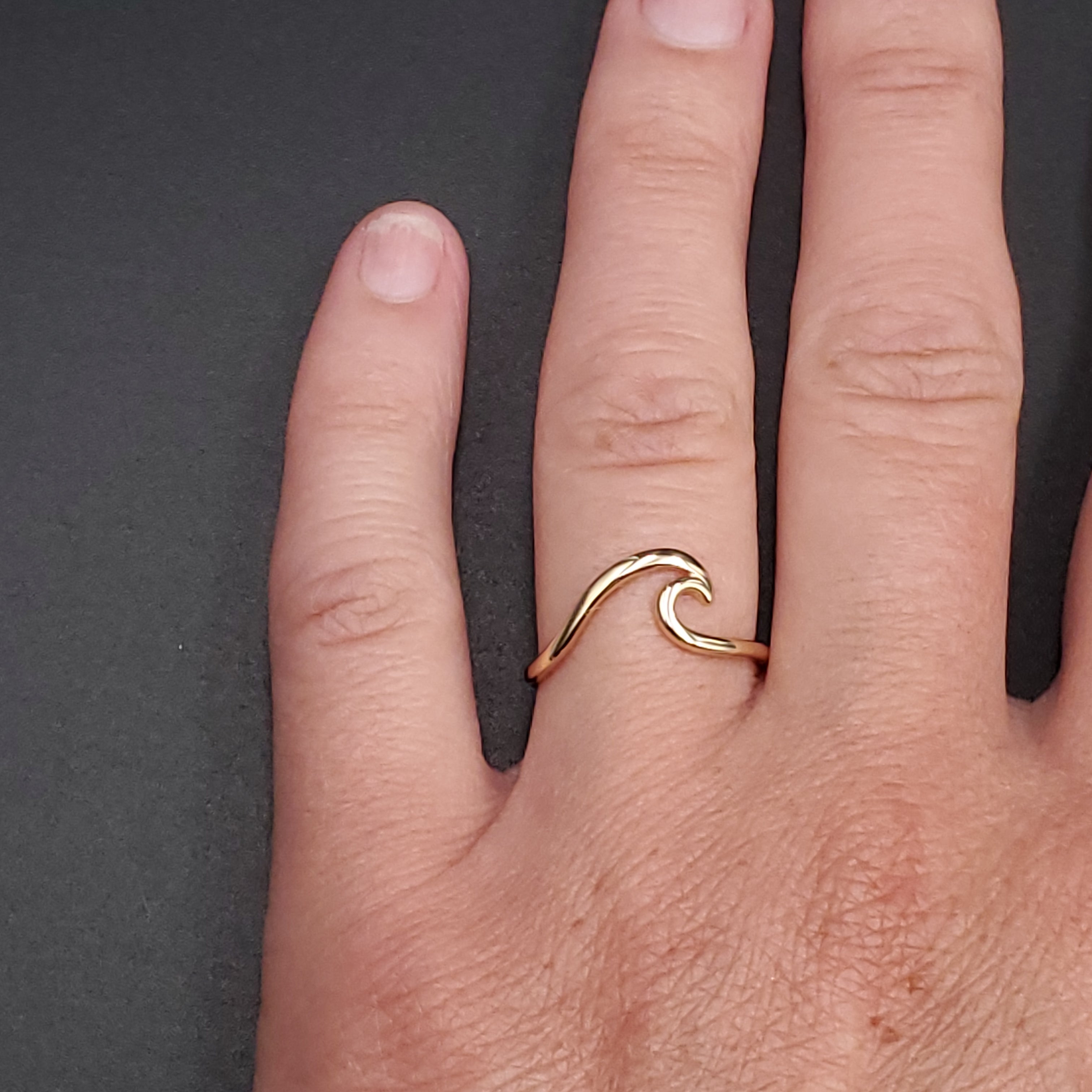 Gold wave ring shown on hand