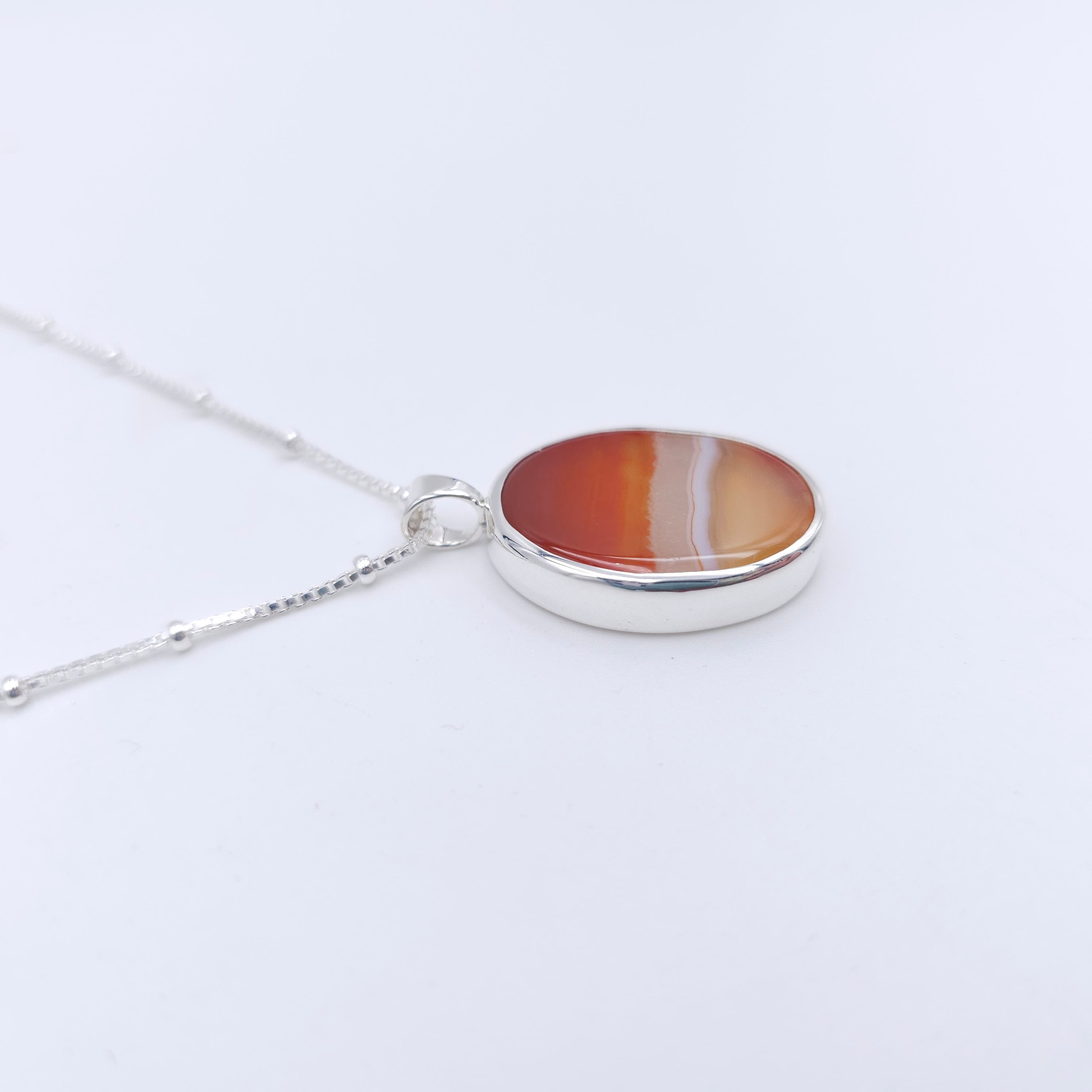 Side view of orange agate pendant