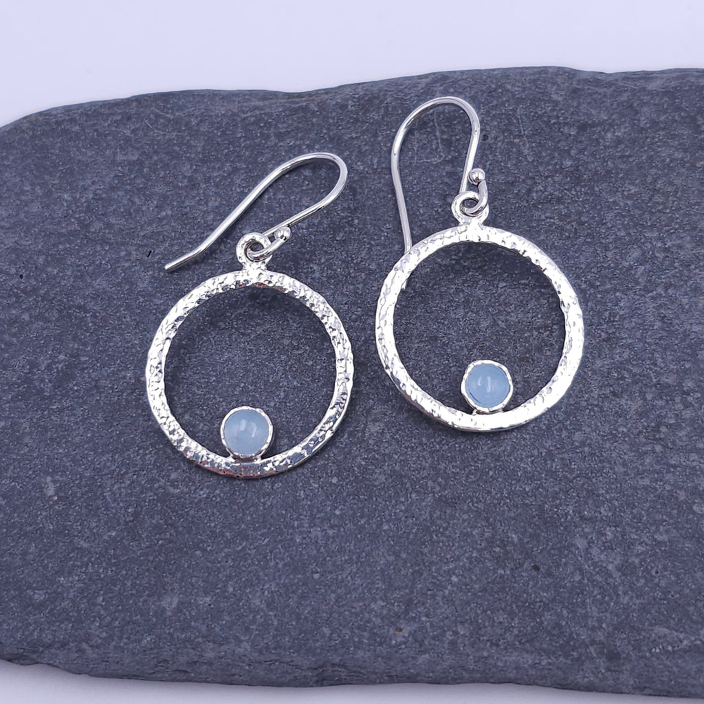 Silver textured circle earrings with blue round aquamarine round stones bezel set on bottom of circle