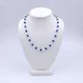 Blue faceted round beaded necklace with silver loops linking the beads together.
