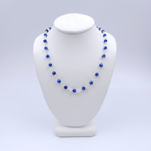 Blue faceted round beaded necklace with silver loops linking the beads together.