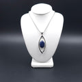 Marquis shaped open silver pendant with bezel set blue sodalite gem inside