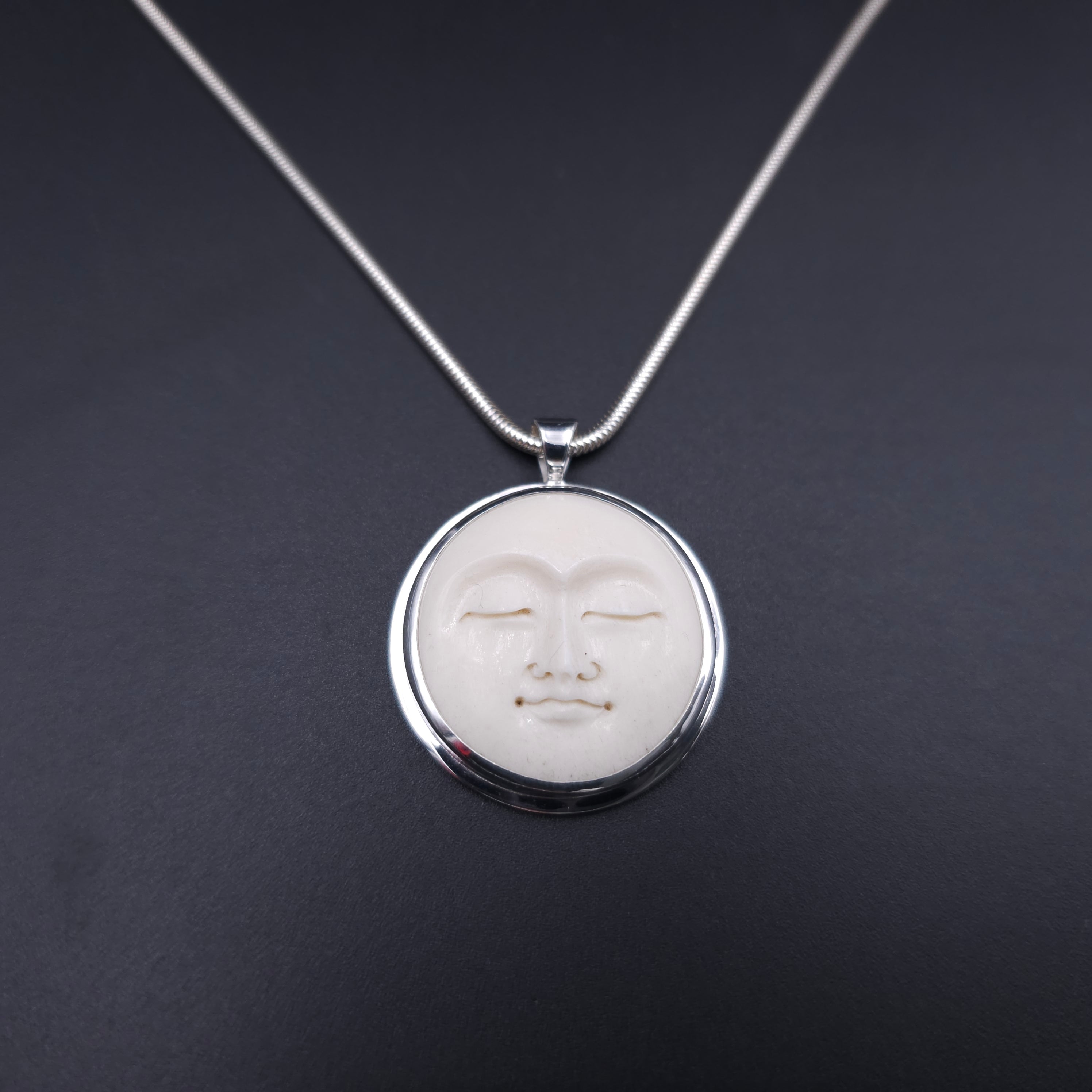 Carved face sterling silver necklace