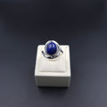 silver spiral ring with bezel set oval blue lapis gemstone in center