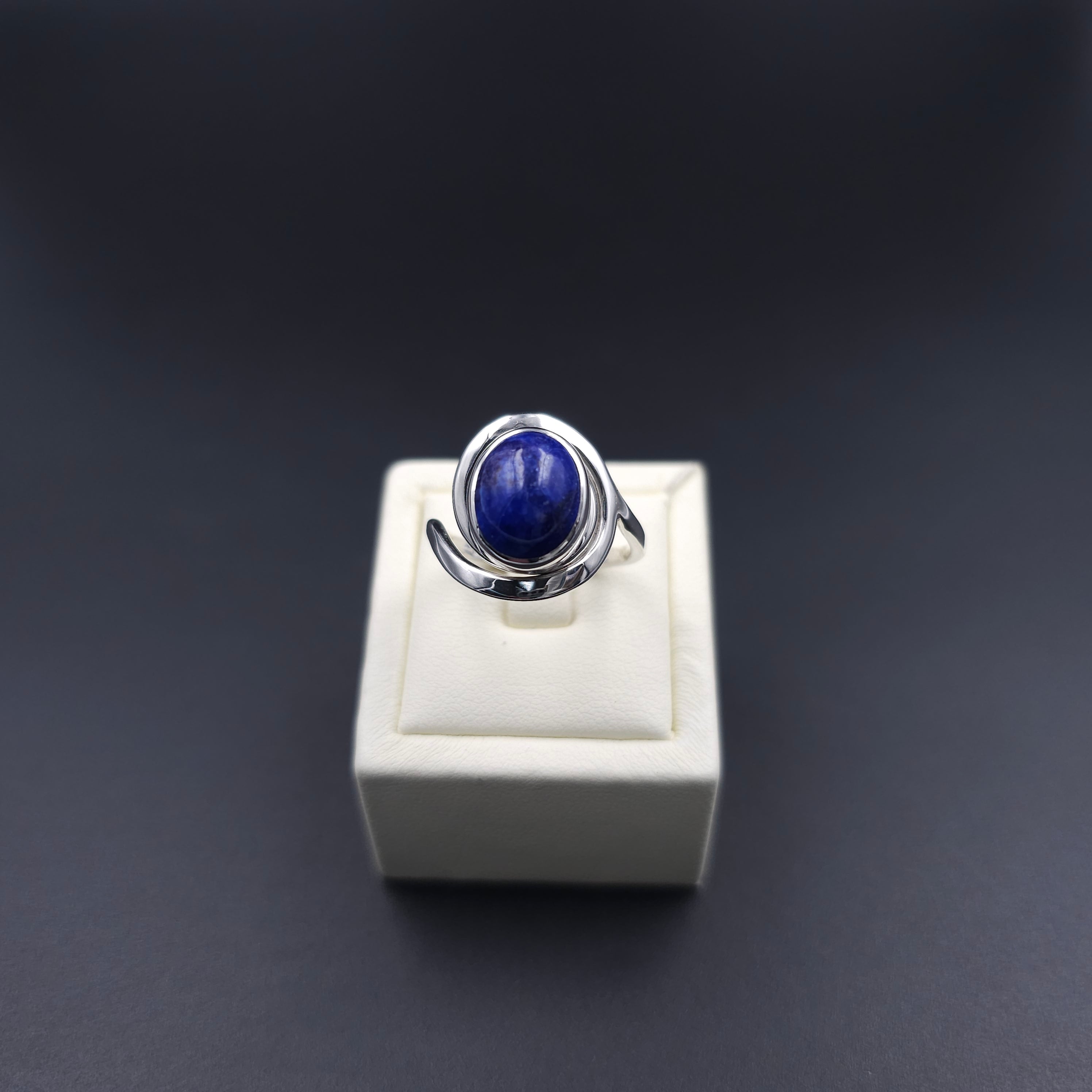 silver spiral ring with bezel set oval blue lapis gemstone in center