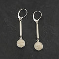 Pair of silver earrings with bezel set carved face designs hanging from square brushed finished silver pieces