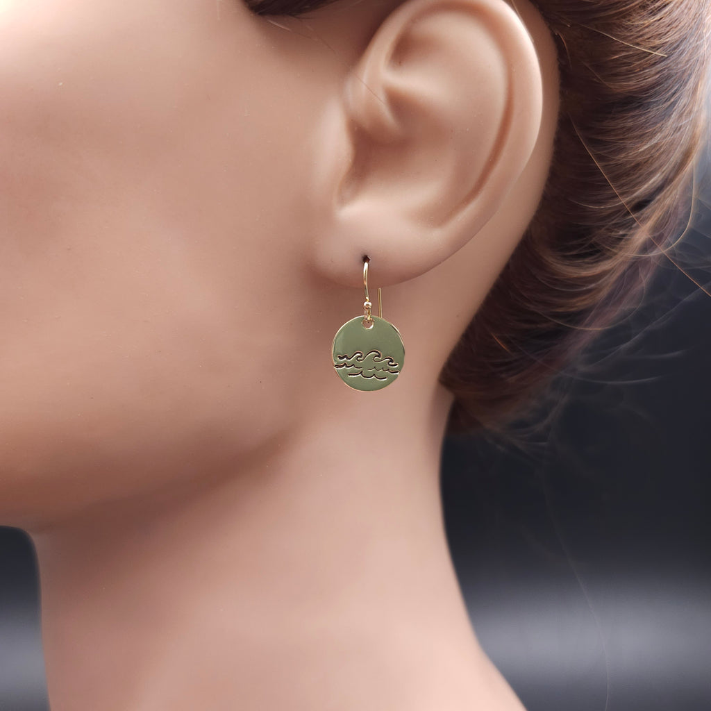 Round disc dangle earrings with blackened waves pattern.