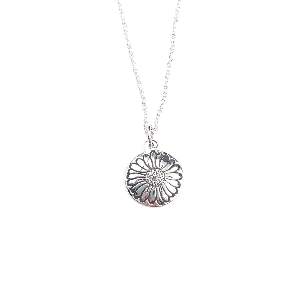 A silver stamped daisy round pendant necklace on a delicate silver chain