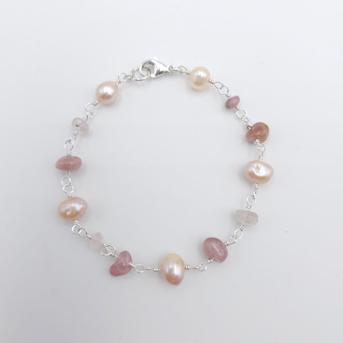 Silver link bracelet with tourmaline beads and pearls, connected by wire wrapped loops.