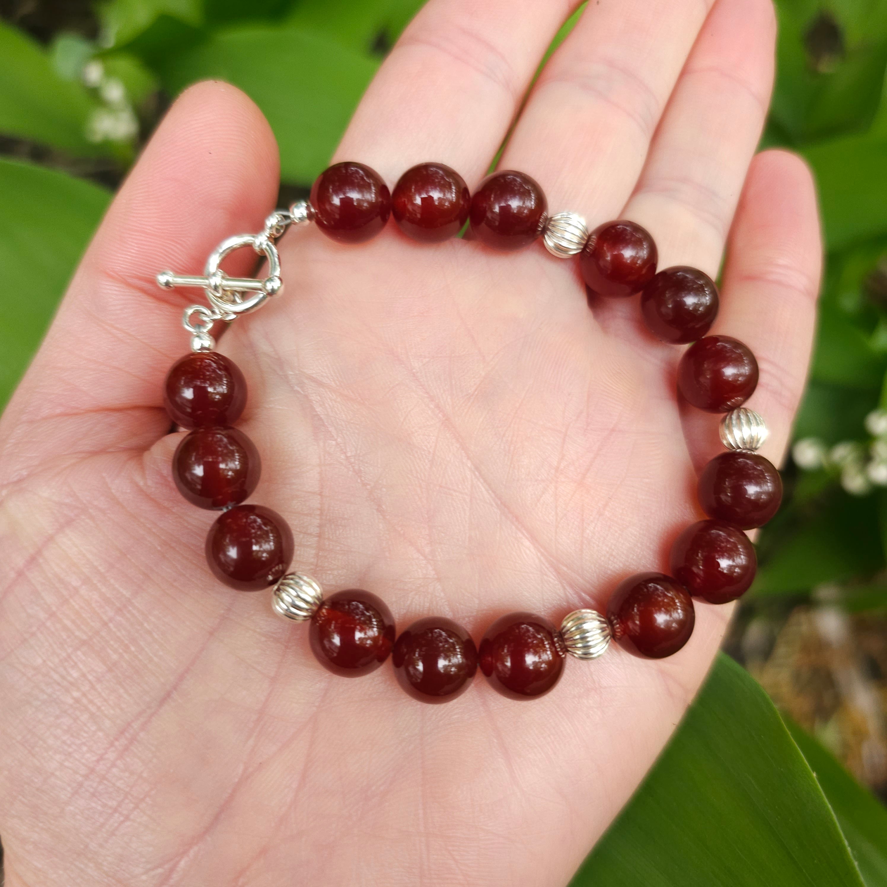 Large round dark red carnelian beaded bracelet with corrugated silver bead accents and toggle clasp