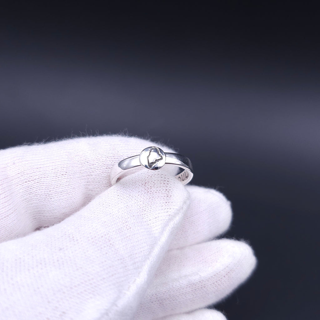Silver ring with a domed circle with the outline of the state of Maine attached to the ring shank.