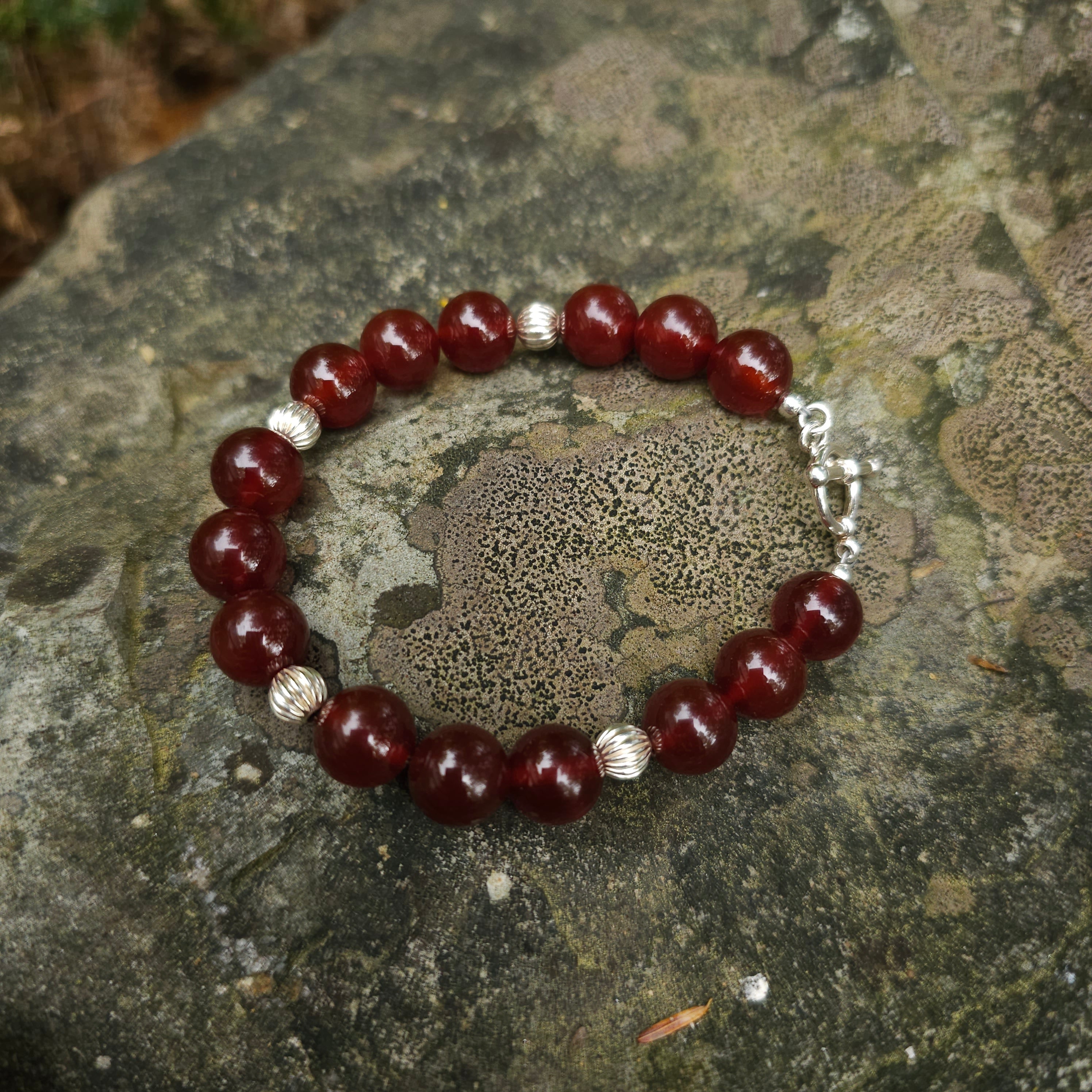 Carnelian beaded bracelet displayed on rock