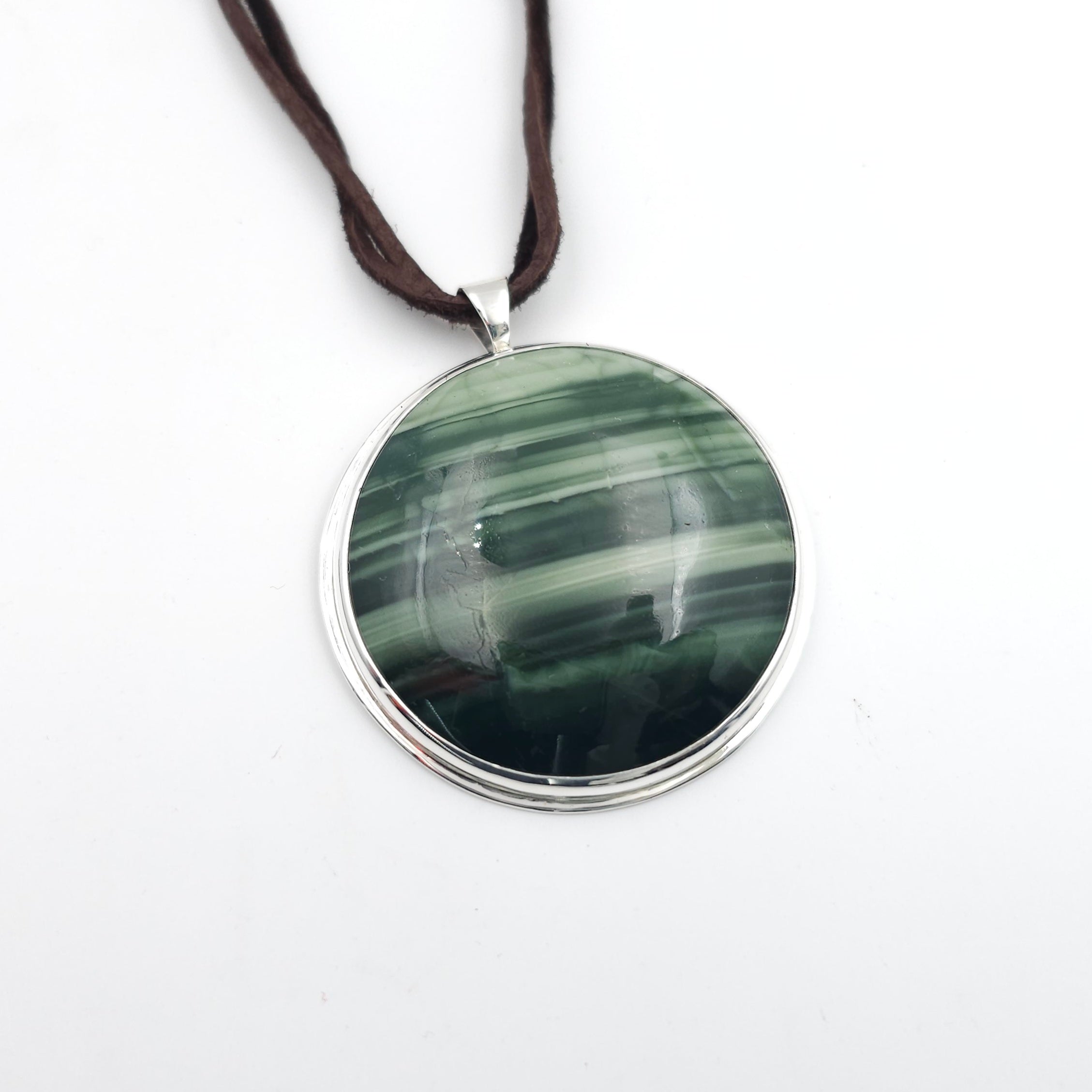 Necklace with dark green and light green striped gemstone, bezel set and hanging from brown suede cord