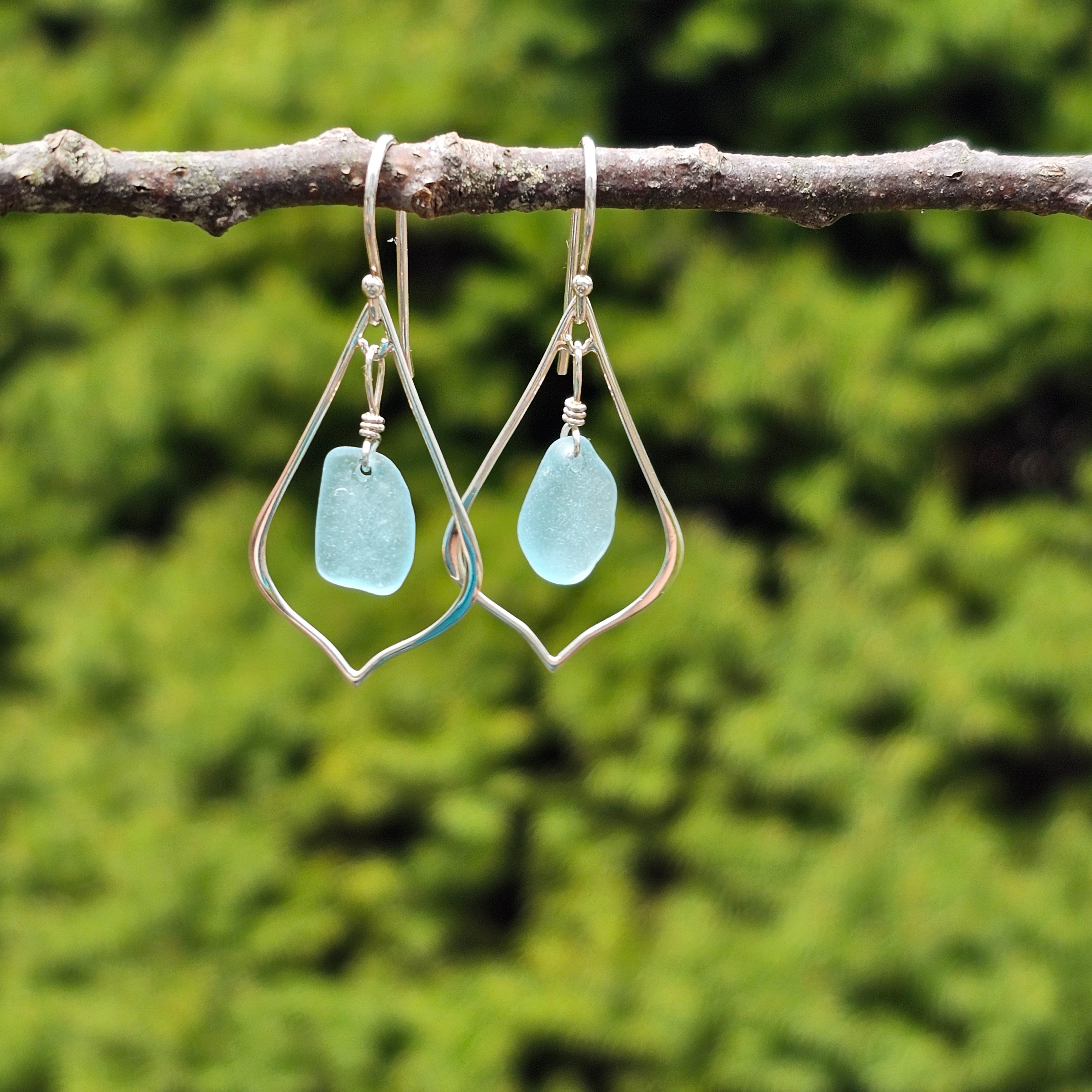 silver wire pointed teardrop dangle earrings with light blue sea glass dangling inside teardrop