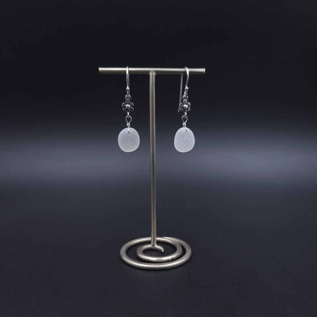 White sea glass dangle earrings with flower accents in sterling silver