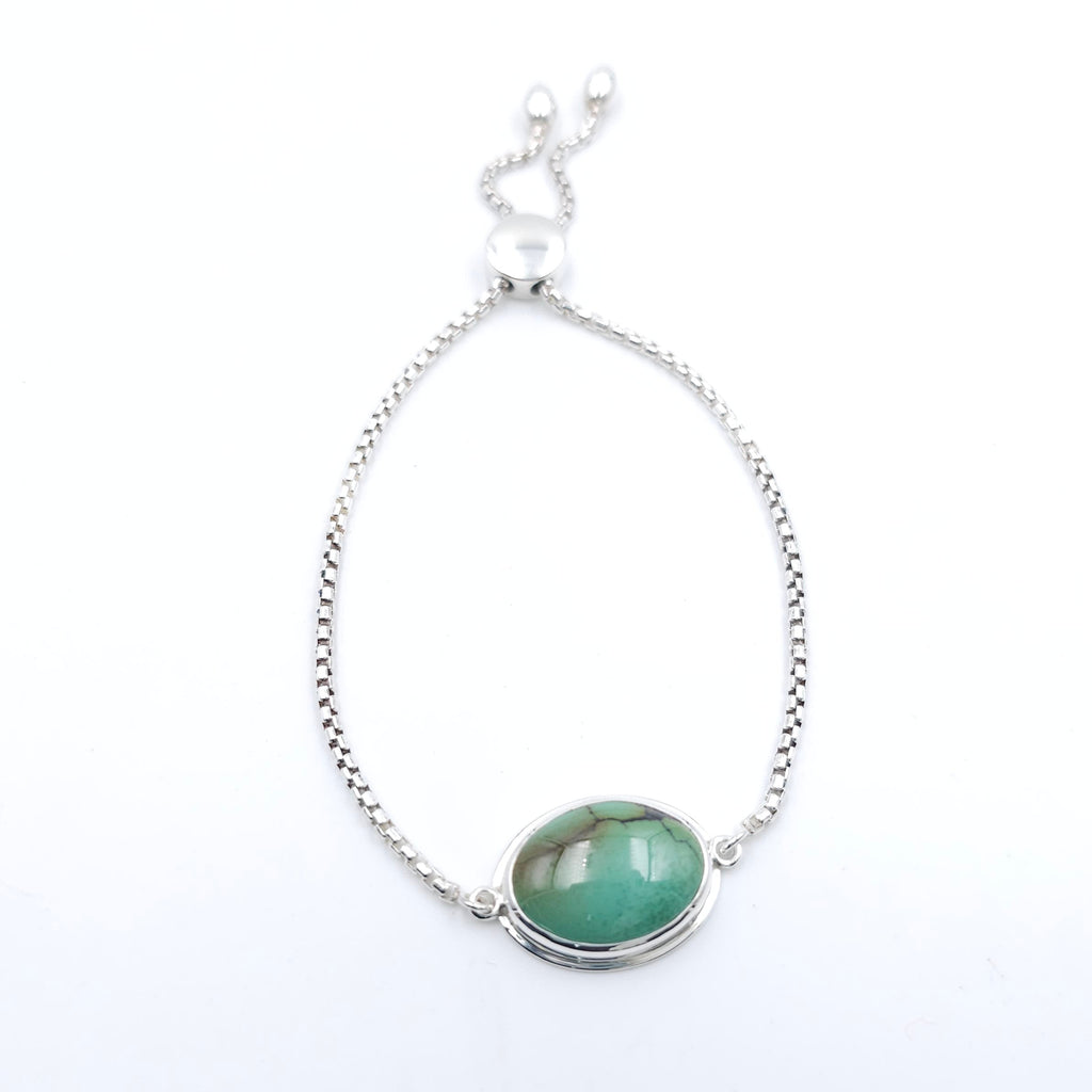 Adjustable silver chain bracelet with bezel set green turquoise with some brown veining