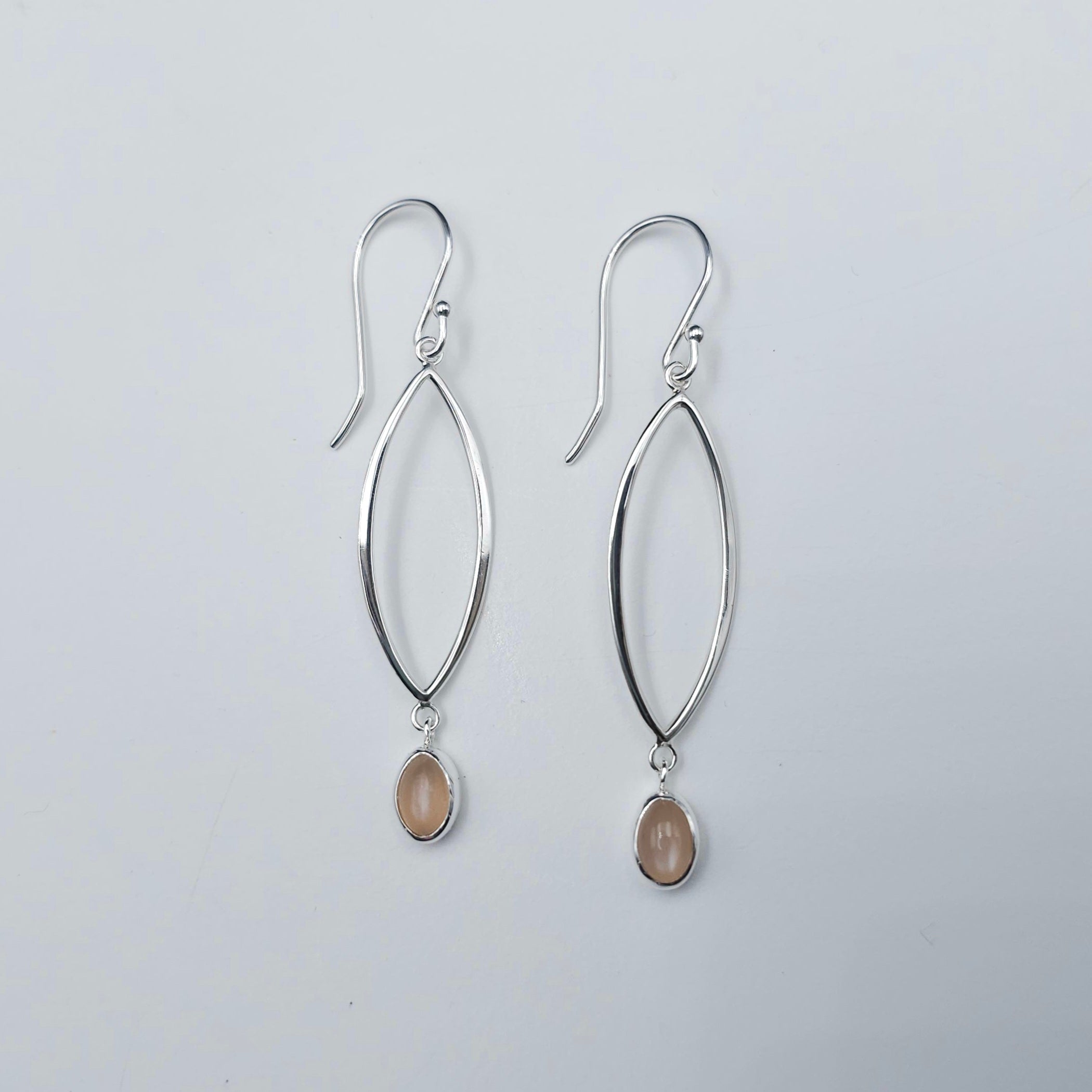 Marquise shaped open silver dangles with small oval peach moonstones dangling below.