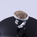 Large oval bezel set brown Jasper with blotches of different shades of brown and black spots
