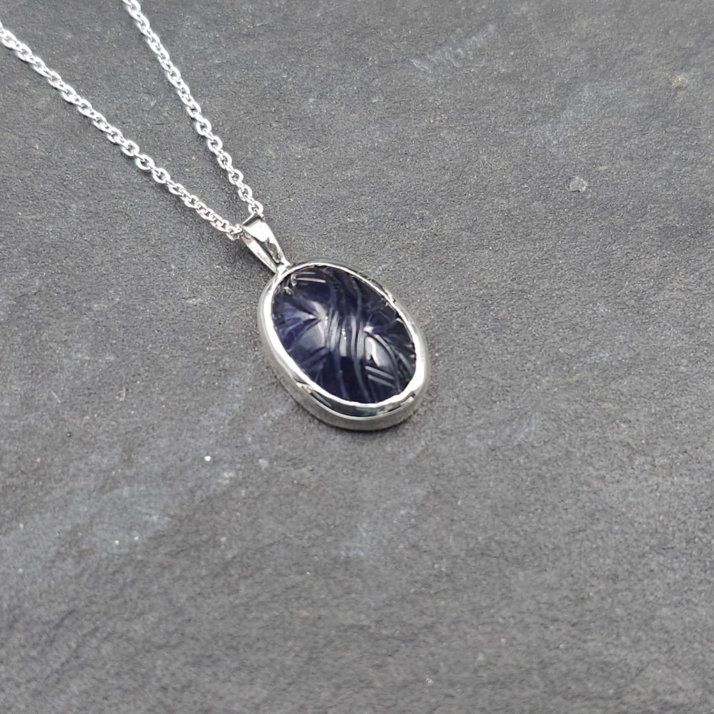 Oval carved dark purple iolite bezel set silver necklace