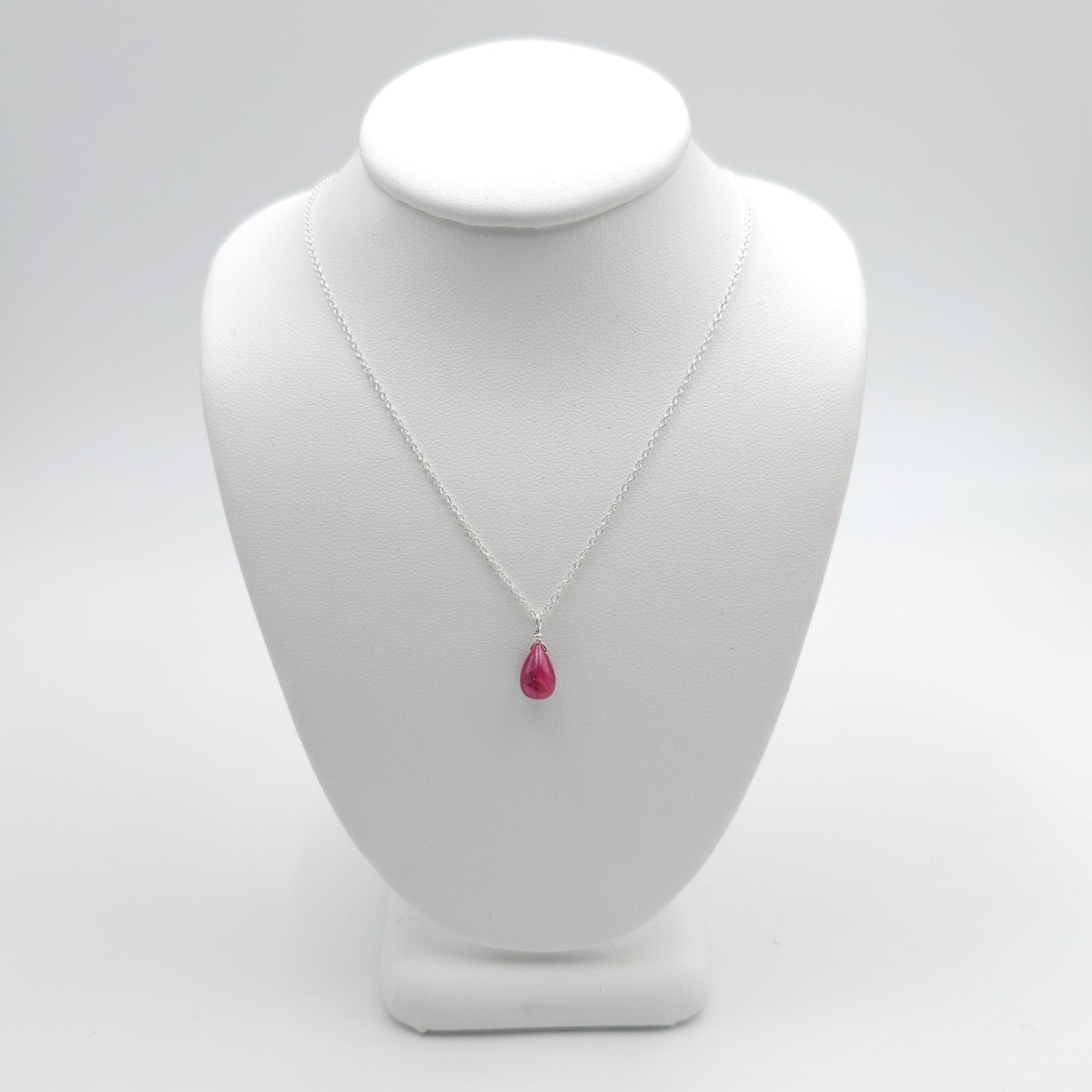 small pinkish red teardrop ruby bead pendant on thin silver cable chain