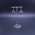 A pair of silver dangle earrings with oval blue kyanite gemstones