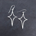 Silver wire formed in an elongated star shape, with a slightly hammered finish, dangling from French earring wires.