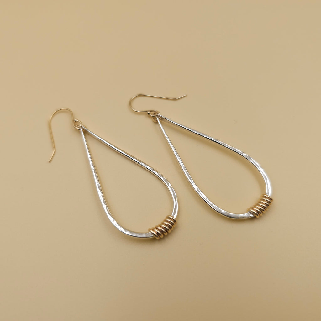 Large silver teardrop hammered earrings with gold-filled wire coil at bottom of teardrop, and gold-filled French earrings wires