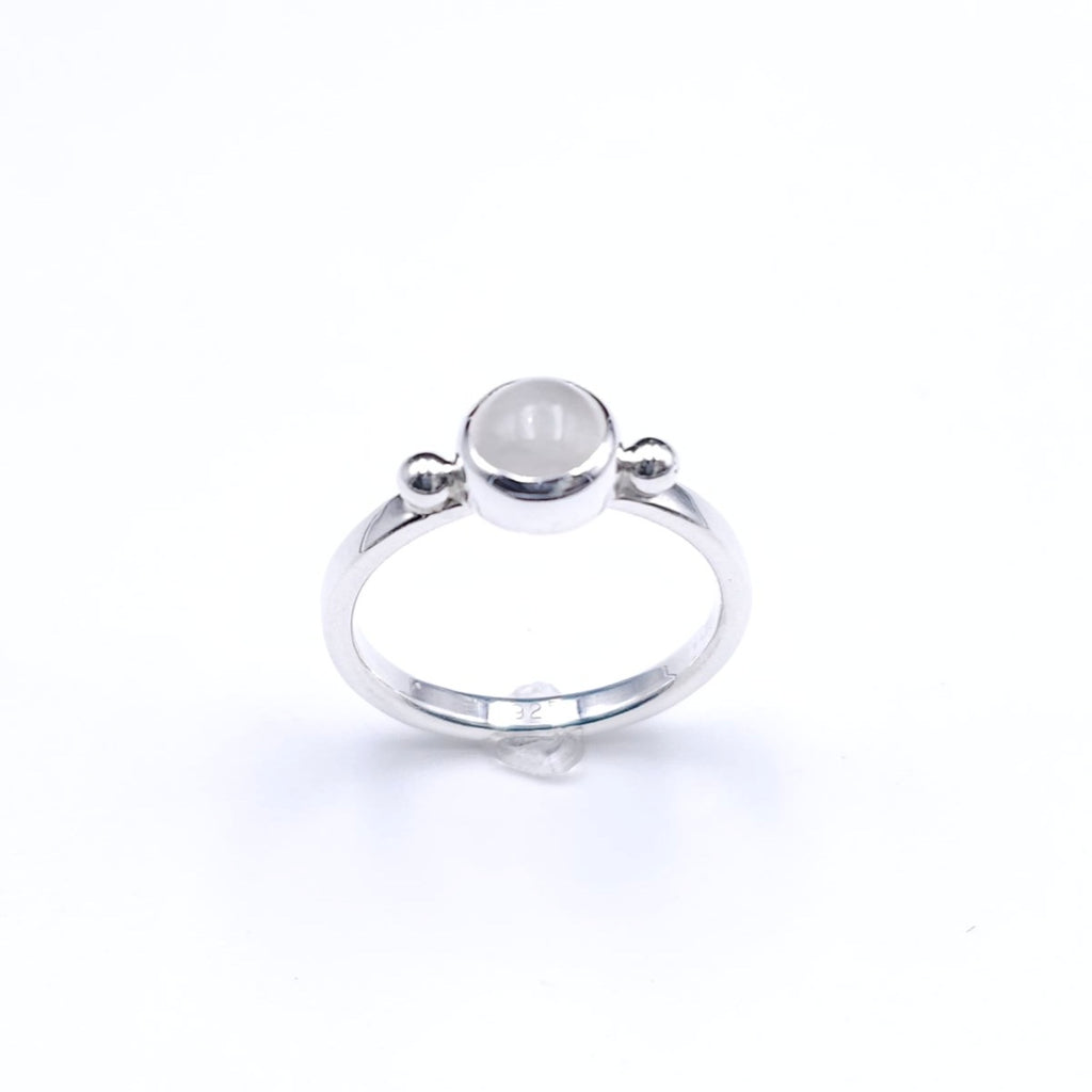 silver ring with bezel set round moonstone and a silver ball on either side of stone