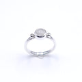 silver ring with bezel set round moonstone and a silver ball on either side of stone