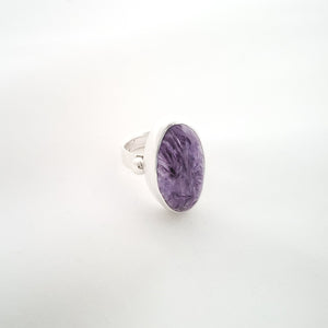 Purple large oval charoite ring shown at side angle