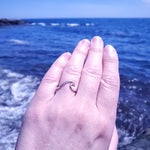 wave ring shown on hand with ocean in background