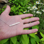 Silver stamped coordinate bar necklace shown on hand
