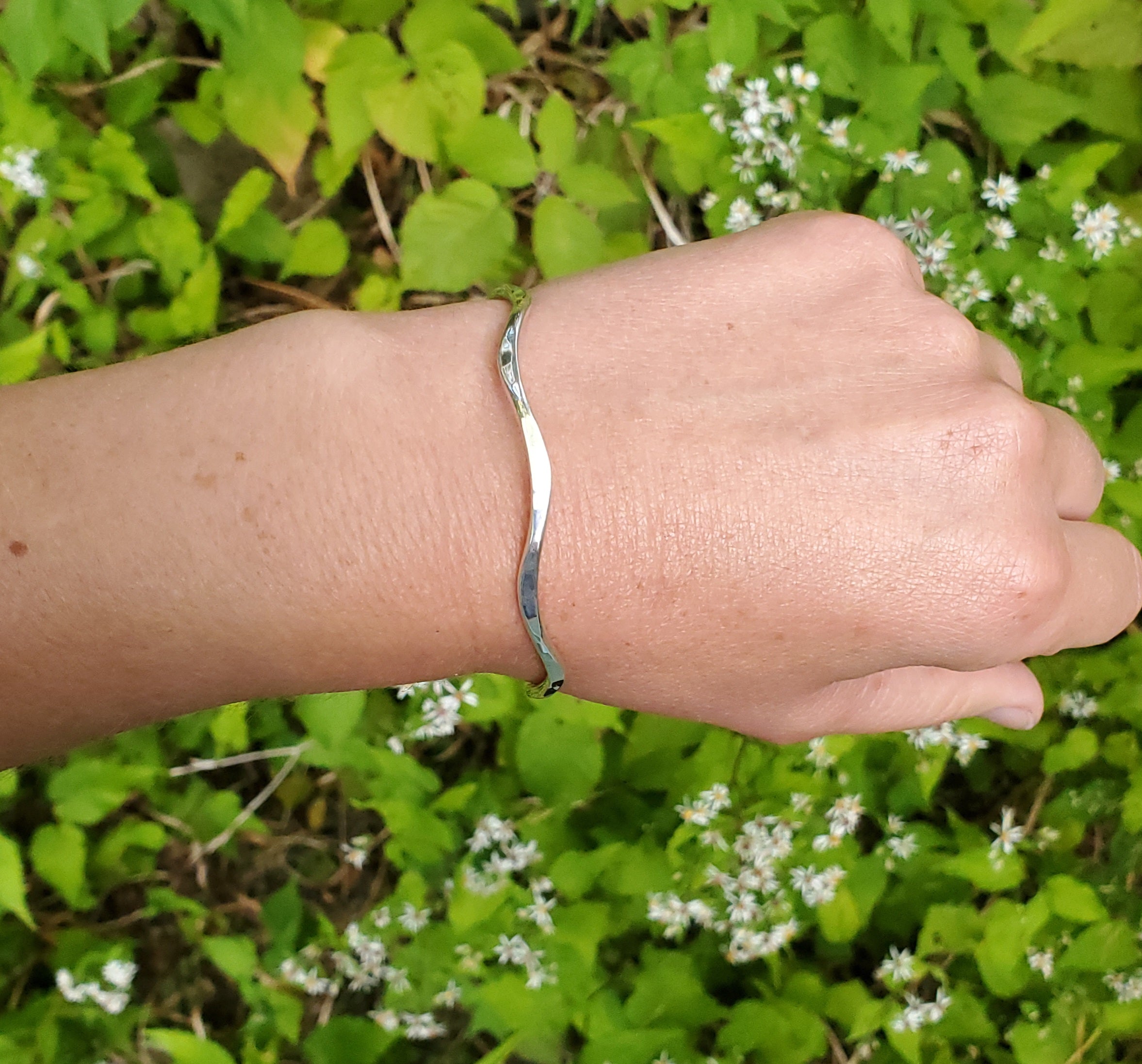 Silver wavy cuff bracelet shown on wrist