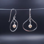 Silver wide teardrop earrings with fresh water pearls dangling in center