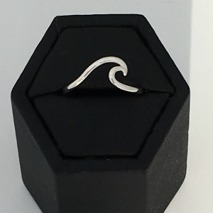 Sterling silver ring with a wave on the top dispalyed in black hexagon ring display