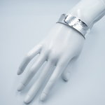 Wide silver cuff shown on mannequin hand