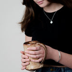 Double name bracelet shown on model holding coffee cup
